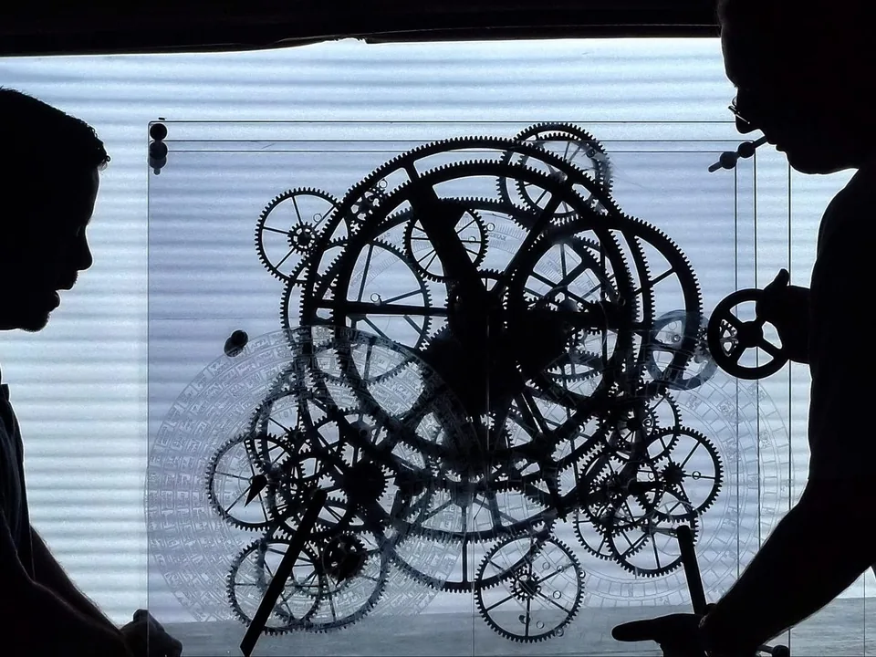 People examining the enlarged Antikythera mechanism model built for National Geographic