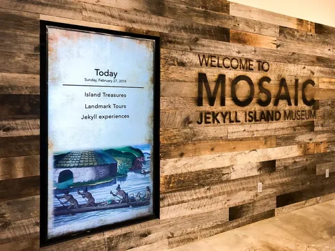 A vertical Mosaic welcome display against the timber wall at the Jekyll Island Museum